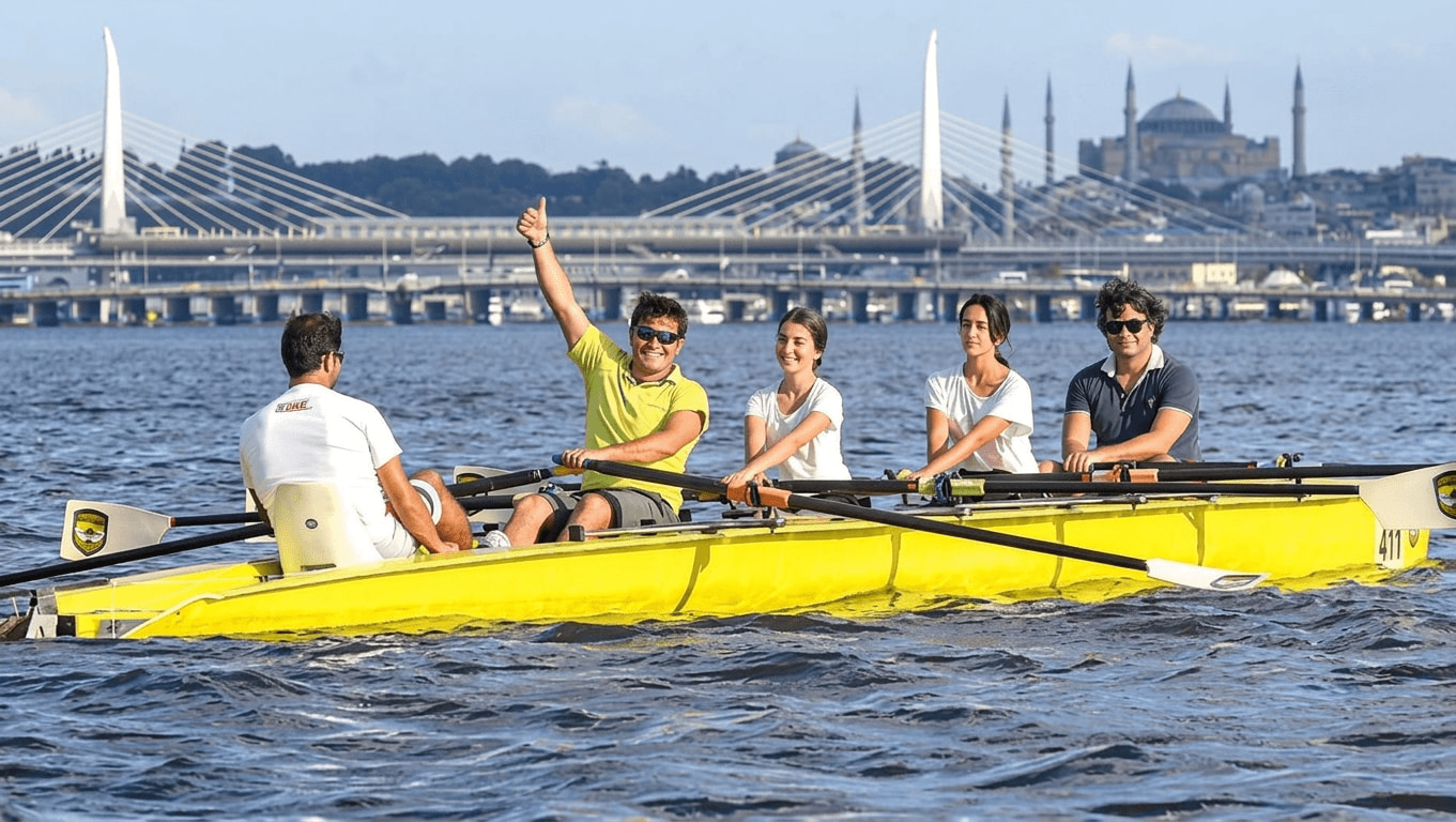 Participants during a rowing session on the Golden Horn with the Istanbul skyline in the background